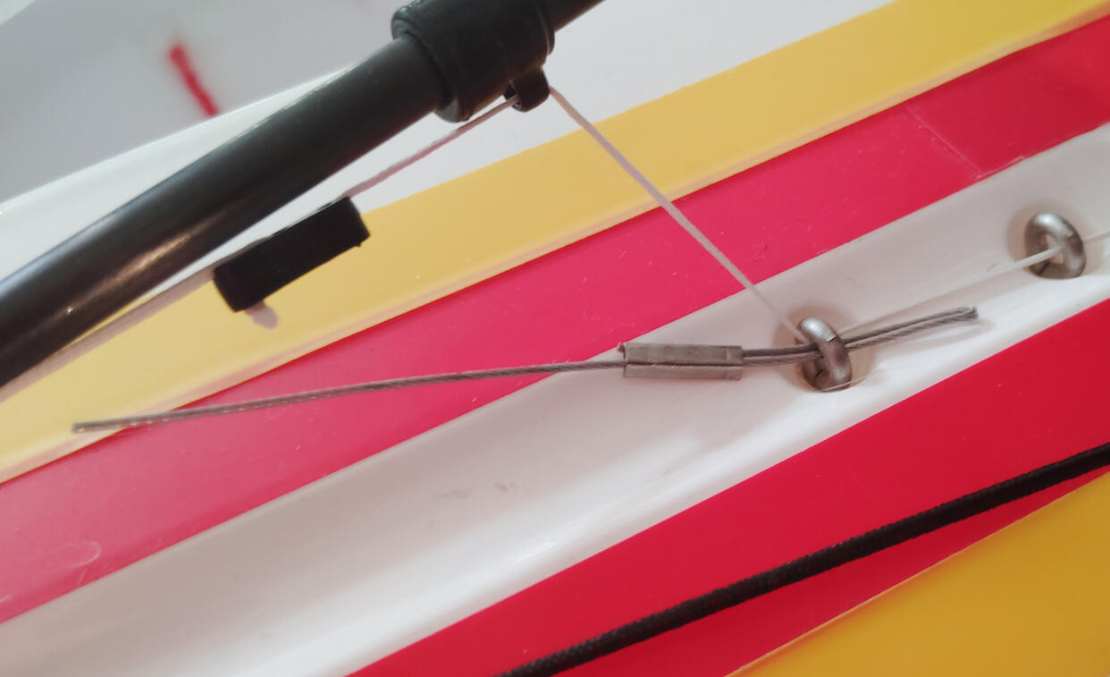 This tool holds in the main boom plumb arrow but doubles as a threader for lines!